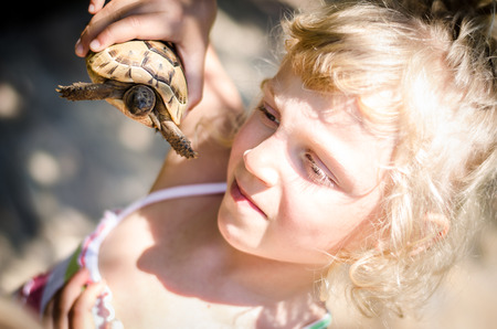 beautiful blond girl with turtle imageの写真素材