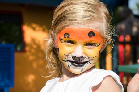 beautiful blond girl with tiger face paintingの写真素材