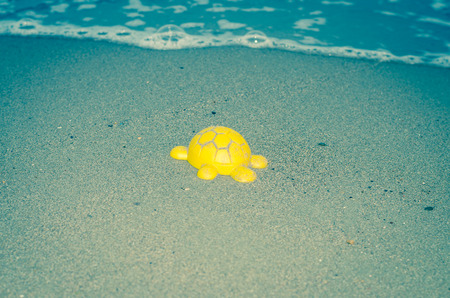 turtle toy on sand on the beachの写真素材
