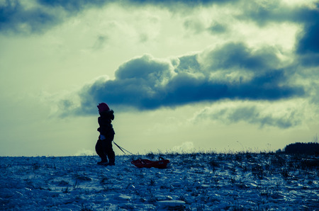 winter scene with child and sledの写真素材
