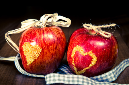 two red apples with yellow heart on themの写真素材