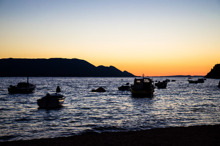 silhouette of boats on sea at sunsetの写真素材