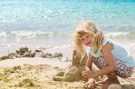 girl playing with sand in the beachの写真素材