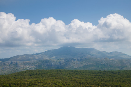 mountaious landscape with white clouds over mountainsの写真素材