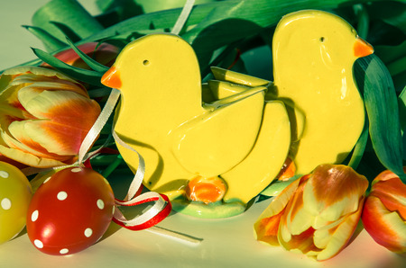 colorful easter eggs with dots, home made chicken decoration and tulips decoration isolatedの写真素材