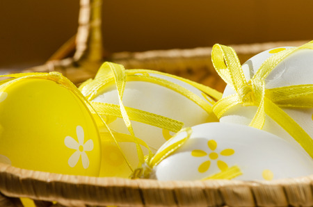 yellow and white easter eggs with dots decoration in backetの写真素材