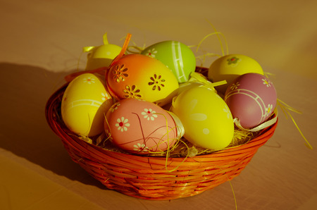 colorful easter eggs over yellow straw in the basket