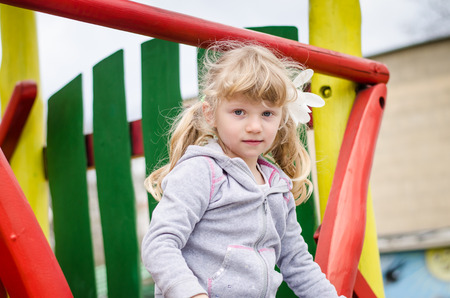 beautiful blond girl child playing on the playgroundの写真素材