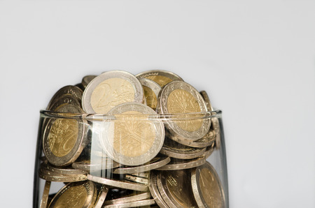 coins in glass on white backgroundの写真素材