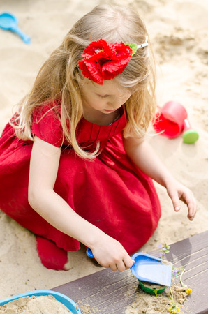beautiful blond girl playing in sandboxの写真素材