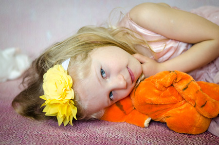 beautiful girl lying and holding plush toyの写真素材