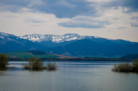 pond and mountains with snowy peaksの写真素材