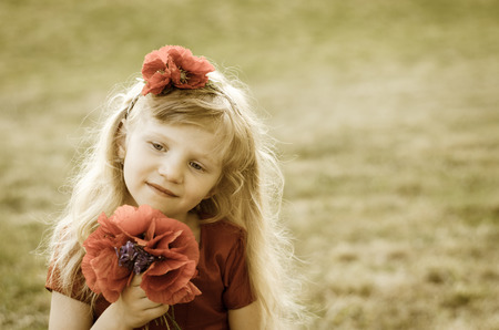 blond girl with long hair and red flowers sepia tonedの写真素材