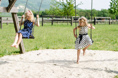 little blond girl swinging outdoorの写真素材