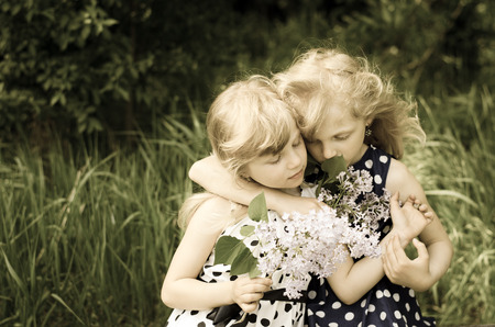 two beautiful blond girls hugingの写真素材