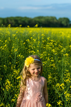portrait of beautiful blond girl in rapeseed fieldの写真素材