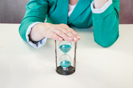 hand over  green sandglass conceptの写真素材