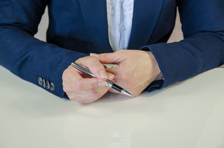 female hand on working desk holding a penの写真素材