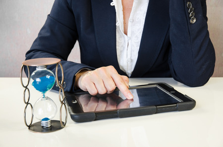 female hand typing into tablet behing working desk