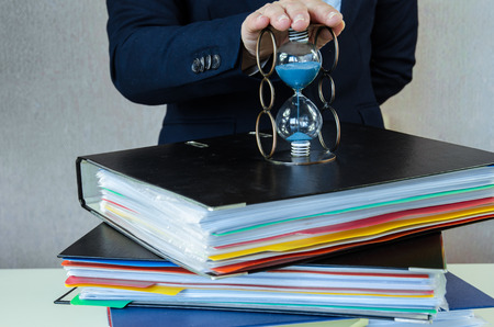 hands on files with data and sandglass