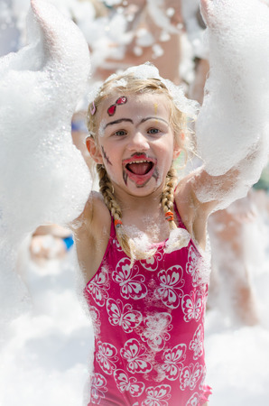 smiling blond girl enjoying foam partyの写真素材