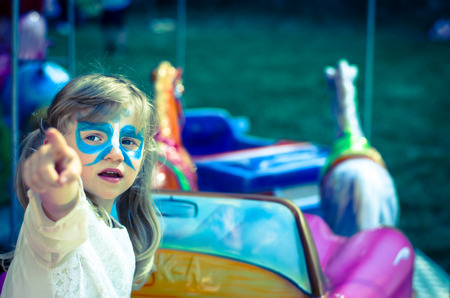 girl with facepainting of blue butterfly in marry-go-roundの写真素材