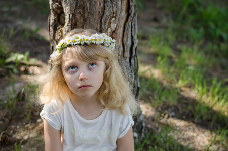 adorable little blond girl with daisy flower headbandの写真素材
