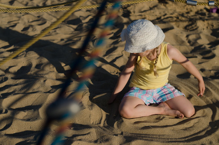 little girl playing in sand playgroundの写真素材