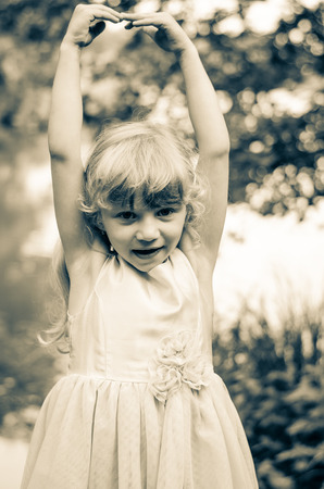 little blond girl dancing sepia effectの写真素材