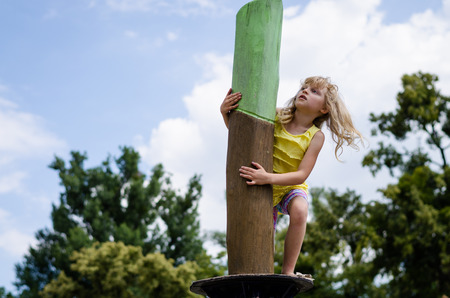 happy child playing outdoor on playgroundの写真素材