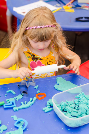 beautiful blond girl playing with plasticineの写真素材
