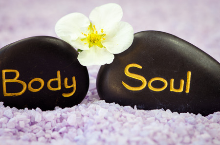 pink sea salt, white flower and black lava stone with words soul and bodyの写真素材