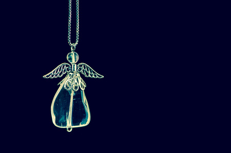 crystal angel decoration against blue backgroundの写真素材
