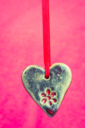 hanged brown ceramics heart purple backgroundの写真素材