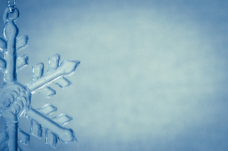 crystal snowflake decoration against blue backgroundの写真素材
