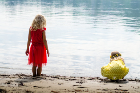 beautiful blond girls nymphs standing by the river strand rear viewの写真素材