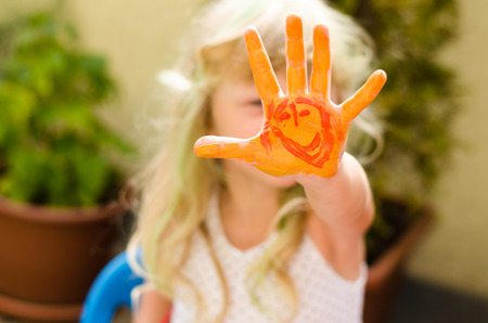 blond girl with colorful painted handsの写真素材