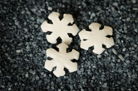 white snow flakes against black background