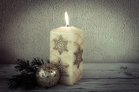 golden burning candles decoration against pink backgroundの写真素材