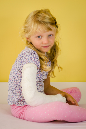 hurt blond kid with broken hand in bandageの写真素材