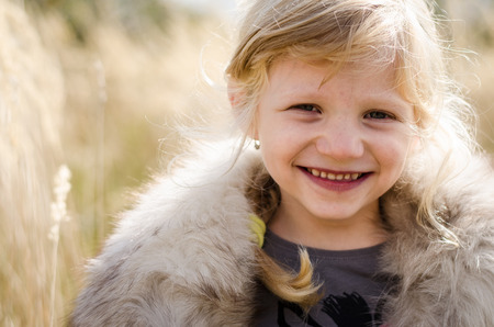 beautiful little happy smiling blond girl portraitの写真素材