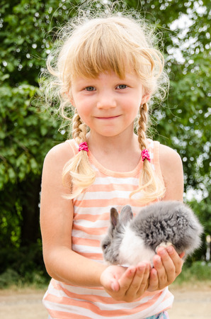 beautiful blond girl holding young bunny rabbitの写真素材