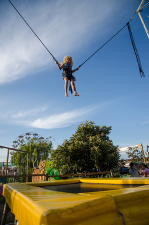 little brave kid jumping in bungee attractionの写真素材
