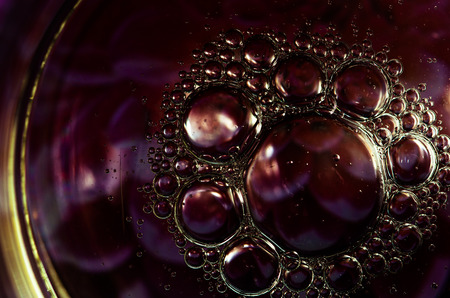 dark purple abstract bubbles made of oil in water surface