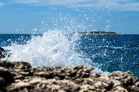 water splash and blue ocean and rocky shoreの写真素材
