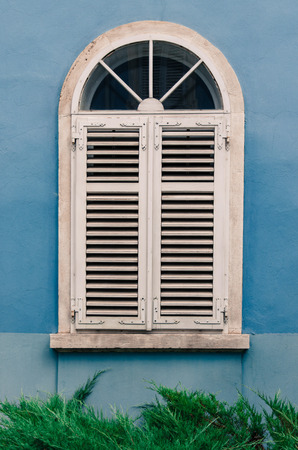 white croatian closed window in blue wallの写真素材