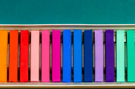 tidy colorful chalks on green board