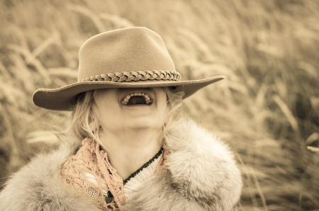 beautiful laughing girl with cowboy hat in her eyesの写真素材