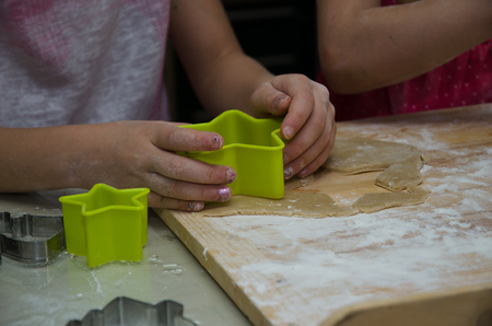 girl in kitchen preparing cookies with shapesの写真素材