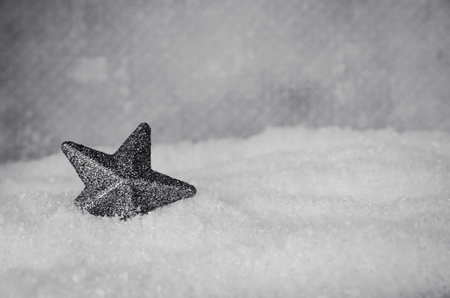 shining silver star decoration in white snowの写真素材